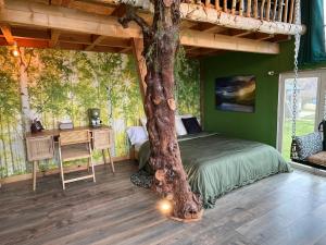 a bedroom with a tree growing out of a bed at La Découverte Trouvée in Auxon