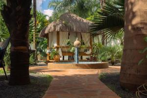 a small hut with a bench and a palm tree at Dos Lunas Aparthotel in J. E. Estigarribia