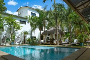 a swimming pool in front of a house with palm trees at Dos Lunas Aparthotel in J. E. Estigarribia