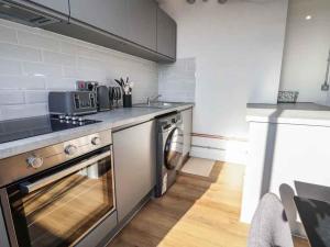 a kitchen with a stove and a dishwasher at Woolston Central 2-Bedroom Apartment in Warrington