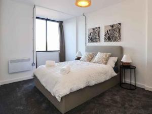 a bedroom with a large white bed with two lamps at Woolston Central 2-Bedroom Apartment in Warrington