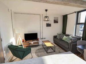 a living room with a couch and a tv at Woolston Central 2-Bedroom Apartment in Warrington +22 photos