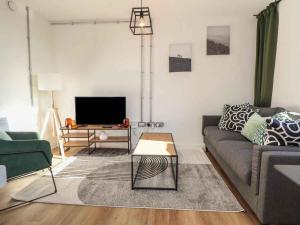 a living room with a couch and a tv at Woolston Central 2-Bedroom Apartment in Warrington