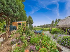 a garden with a small house and a boat at Glenshee Suite, Beechtree Cottage in Kirkmichael