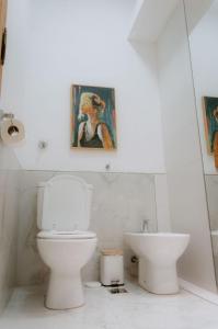 a white bathroom with a toilet and a sink at Mayo apparts in Esperanza