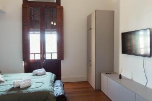 a bedroom with a bed and a flat screen tv at Mayo apparts in Esperanza