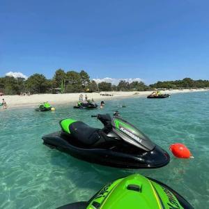 a jet ski in the water next to a beach at ZEcamping 2 étoiles accès direct à la plage chiens acceptés piscine in Ghisonaccia