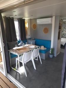 a dining room with a table and chairs in a caravan at ZEcamping 3 étoiles avec piscine chauffée - bar et restaurant in Pézenas