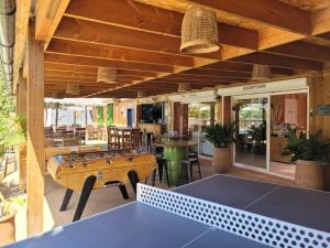a room with a ping pong table on a patio at ZEcamping 3 étoiles avec piscine chauffée - bar et restaurant in Pézenas