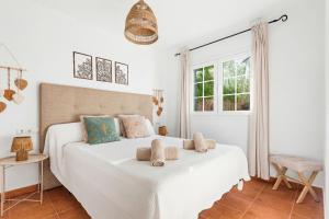 a white bedroom with two beds and a window at Villa Maite by Escape Home in Binibeca +68 photos