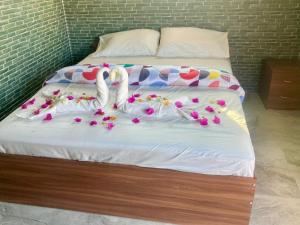 a bed with two swans made out of flowers at Nature's Resort in Kaivār