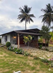 a house with a palm tree in the yard at Nature's Resort in Kaivār