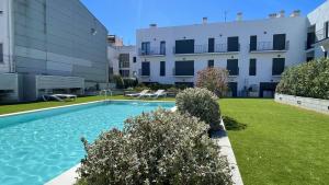 a swimming pool in a yard next to a building at Apartament DARSENA B 2-2 in L'Estartit