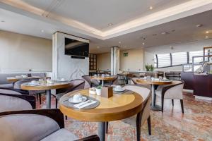a restaurant with tables and chairs and a tv at Best Western Hotel Piccadilly in Rome