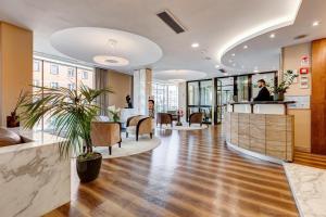 an office lobby with a reception desk and chairs at Best Western Hotel Piccadilly in Rome