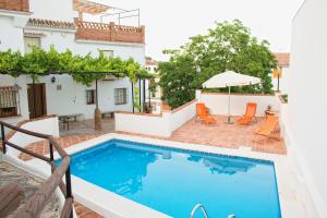 a villa with a swimming pool and a patio at Casa Huerta San Francisco in Casarabonela