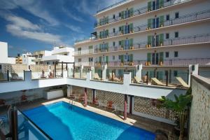 a hotel with a swimming pool in front of a building at Hotel Florencio Ibiza in San Antonio