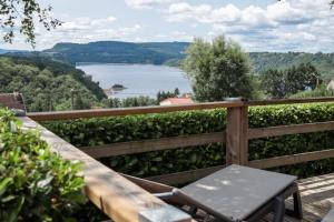 a wooden fence with a table and a view of a lake at Camping 3 étoiles - ccaidff in Beaulieu