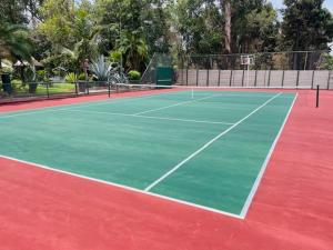 a tennis court with a green and red court at Sunshine Guest House in Harare