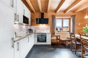 a kitchen with a table and a dining room at Alpen Chalets Ausseerland - Sauna & BBQ in Bad Mitterndorf +63 photos