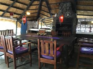 a dining room with a wooden table and chairs at Sunshine Guest House in Harare