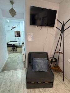 a living room with a chair and a tv on the wall at Berta Gardens 2 in Sandanski