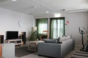 a living room with a couch and a clock on the wall at Scandinavian Dream Guesthouse and Apartments in Rovaniemi