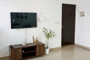 a living room with a tv on a white wall at Indran in Chhatikara