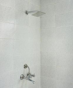 a shower with a shower head in a bathroom at Indran in Chhatikara