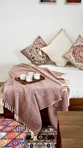 a bed with a tray with three cups on it at Indran in Chhatikara