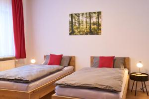 two beds in a room with a picture on the wall at Gästewohnung Schöningen in Schöningen