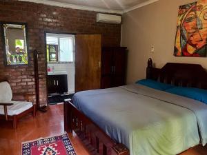 a bedroom with a bed and a brick wall at Sunshine Guest House in Harare +27 photos
