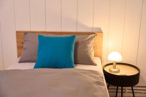 a bedroom with a bed with a blue pillow and a table at Gästewohnung Schöningen in Schöningen