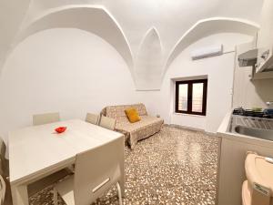 a kitchen and living room with a table and a couch at Scorcio Sul Mare in Gallipoli