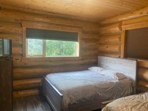 a bedroom with a bed in a log cabin at Cougar Mountain Lodge and Resort Cabin Rentals in Valemount