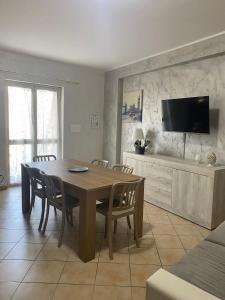a dining room with a wooden table and chairs at Teresan Homestay in Mascali