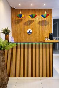 a bar with colorful umbrellas on a wooden wall at Pousada Doce Mar in Maragogi