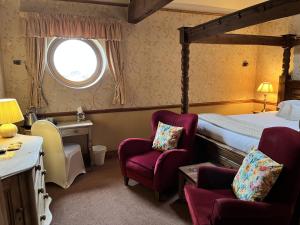 a hotel room with a bed and two chairs at The Dog and Partridge in Langsett