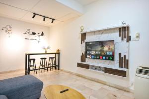 a living room with a tv on a wall at Gathering Double Storey House-10pax in Kampong Pantai Batu Hitam