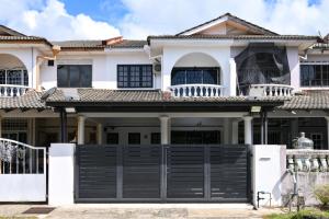 a house with a black gate in front of it at Gathering Double Storey House-10pax in Kampong Pantai Batu Hitam