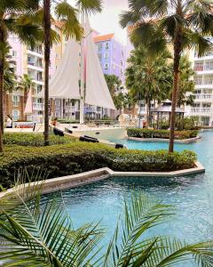 a boat with a sail in a river with palm trees at Seven Seas Code di Azur in Na Jomtien