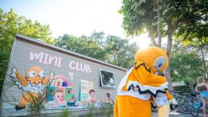 a mascot standing in front of a small building at ZEcamping 5 étoiles avec piscine chauffée dog friendly sauna tennis 3km plage in Vieux-Boucau-les-Bains