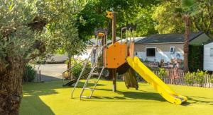a playground with a yellow slide and a slideintend at ZEcamping 5 étoiles avec piscine chauffée dog friendly sauna tennis 3km plage in Vieux-Boucau-les-Bains