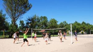 a group of people playing a game of volley ball at ZEcamping 5 étoiles avec piscine chauffée dog friendly sauna tennis 3km plage in Vieux-Boucau-les-Bains