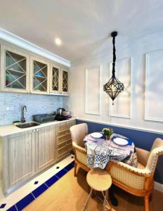 a kitchen with a table and chairs and a sink at Seven Seas Code di Azur in Na Jomtien