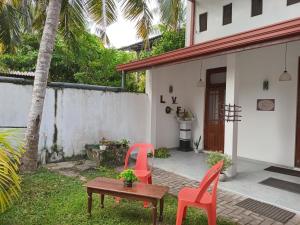two chairs and a table in front of a house at Villa Keturah in Katunayaka