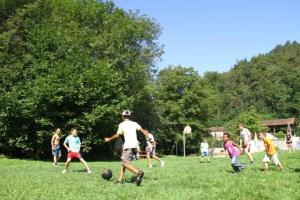 a group of people playing soccer in a field at ZEcamping 4 pet friendly club enfant piscine bar et restanrant in La Bastide-de-Sérou +15 photos