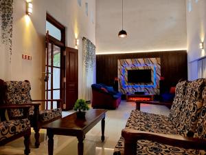 a living room with chairs and a table and a fireplace at Villa Keturah in Katunayaka