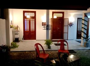a room with two red chairs and two doors at Villa Keturah in Katunayaka
