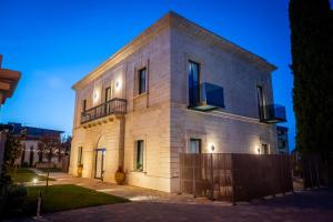 a building with a fence in front of it at Casale della Vittoria - Guest House in Taranto